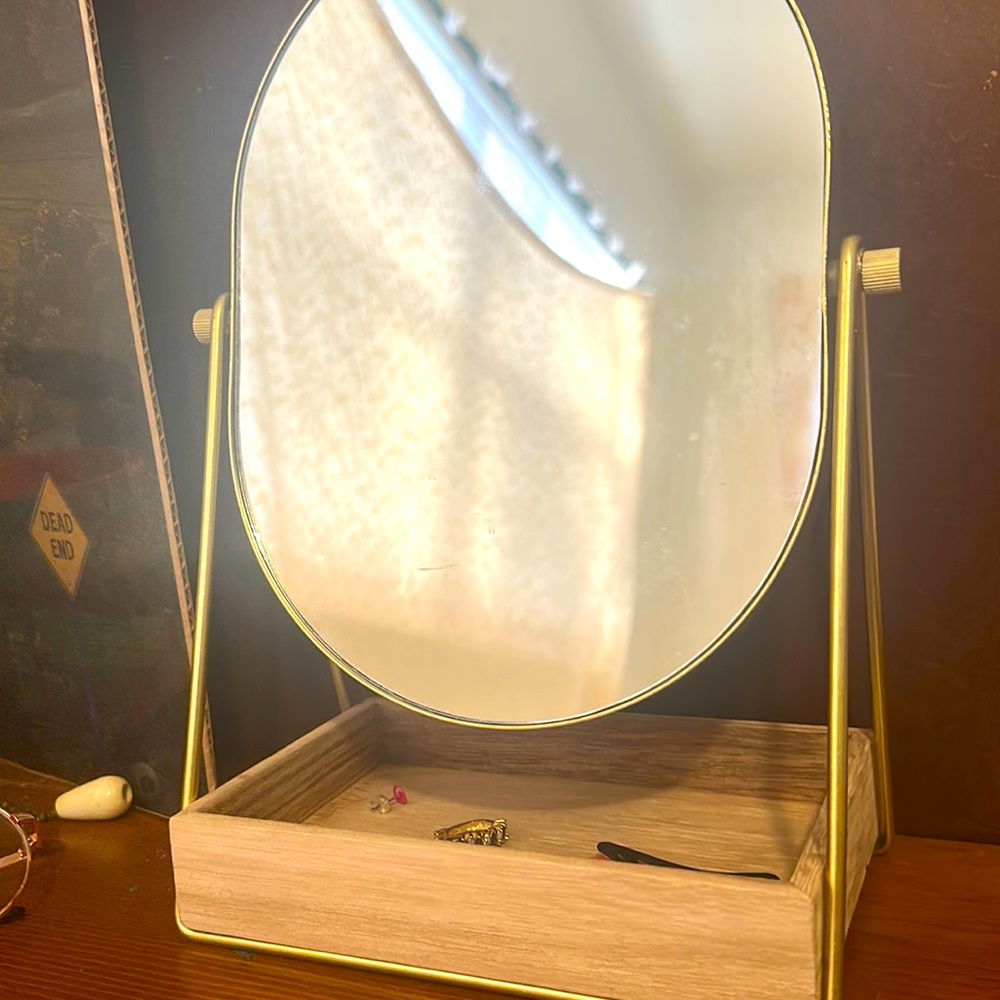 Small beauty mirror with storage spot underneath.